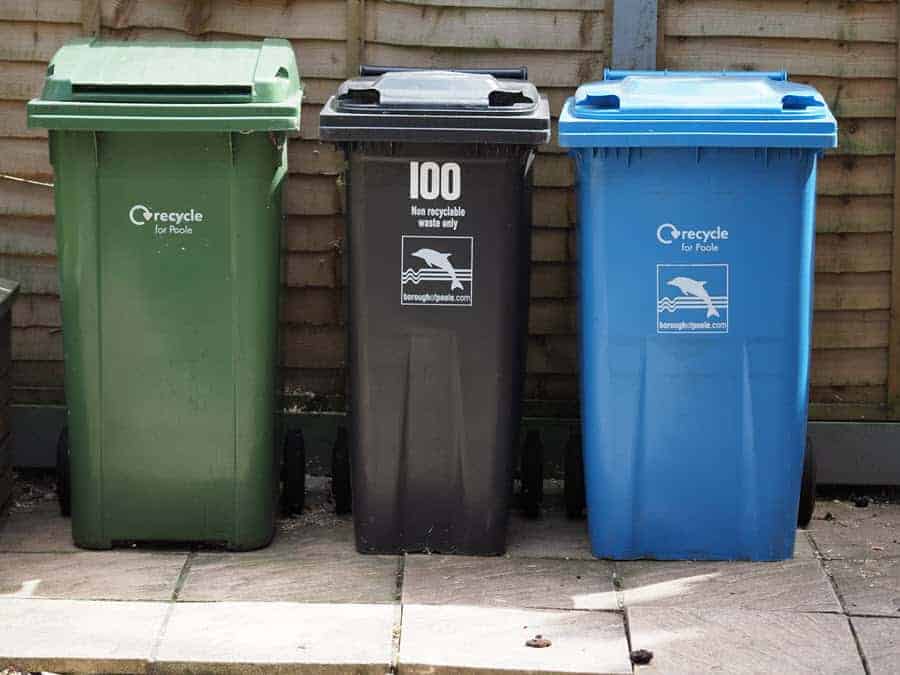 three bins out on pavement, one numbered with stickers