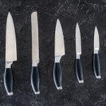 kitchen knives set laid out on surface