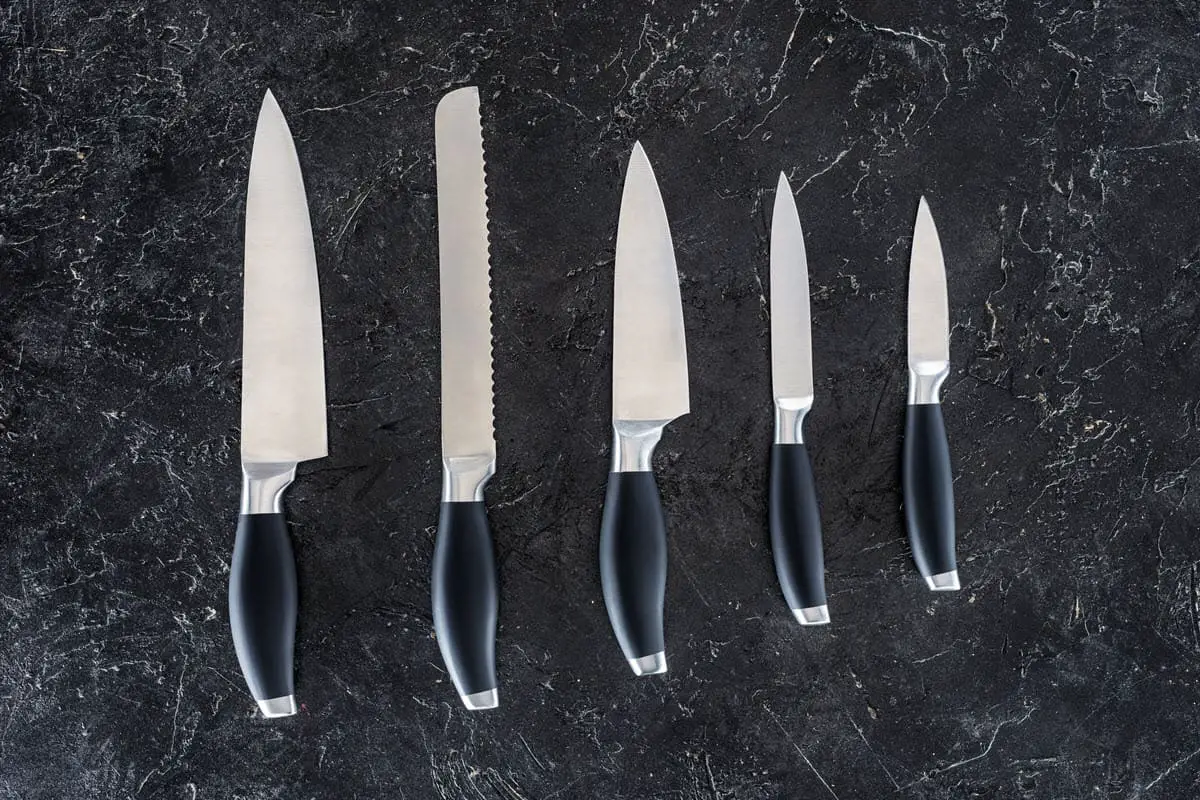 kitchen knives set laid out on surface