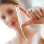 blurred image of woman holding a tampon in focus