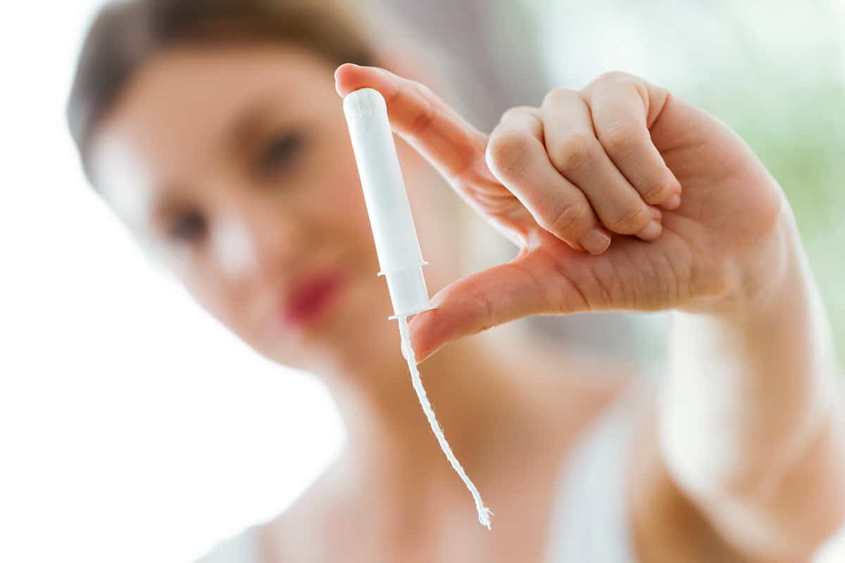 blurred image of woman holding a tampon in focus