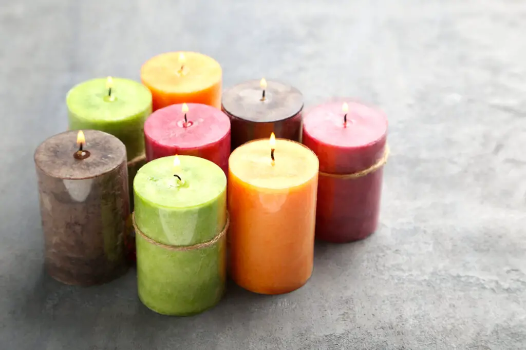 coloured candles burning on a grey surface