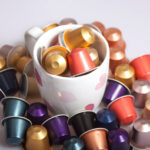 coffee capsules scattered in and around mug